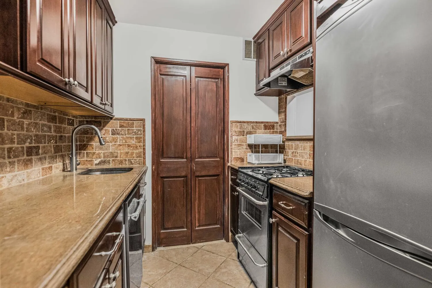 a kitchen with stainless steel appliances granite countertop a refrigerator and a sink