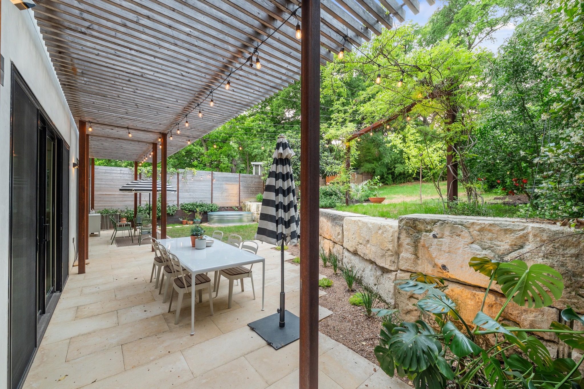 1206 Bickler Road Austin, TX 78704 - Photo 63 of 65 a view of a patio with a table chairs and a backyard