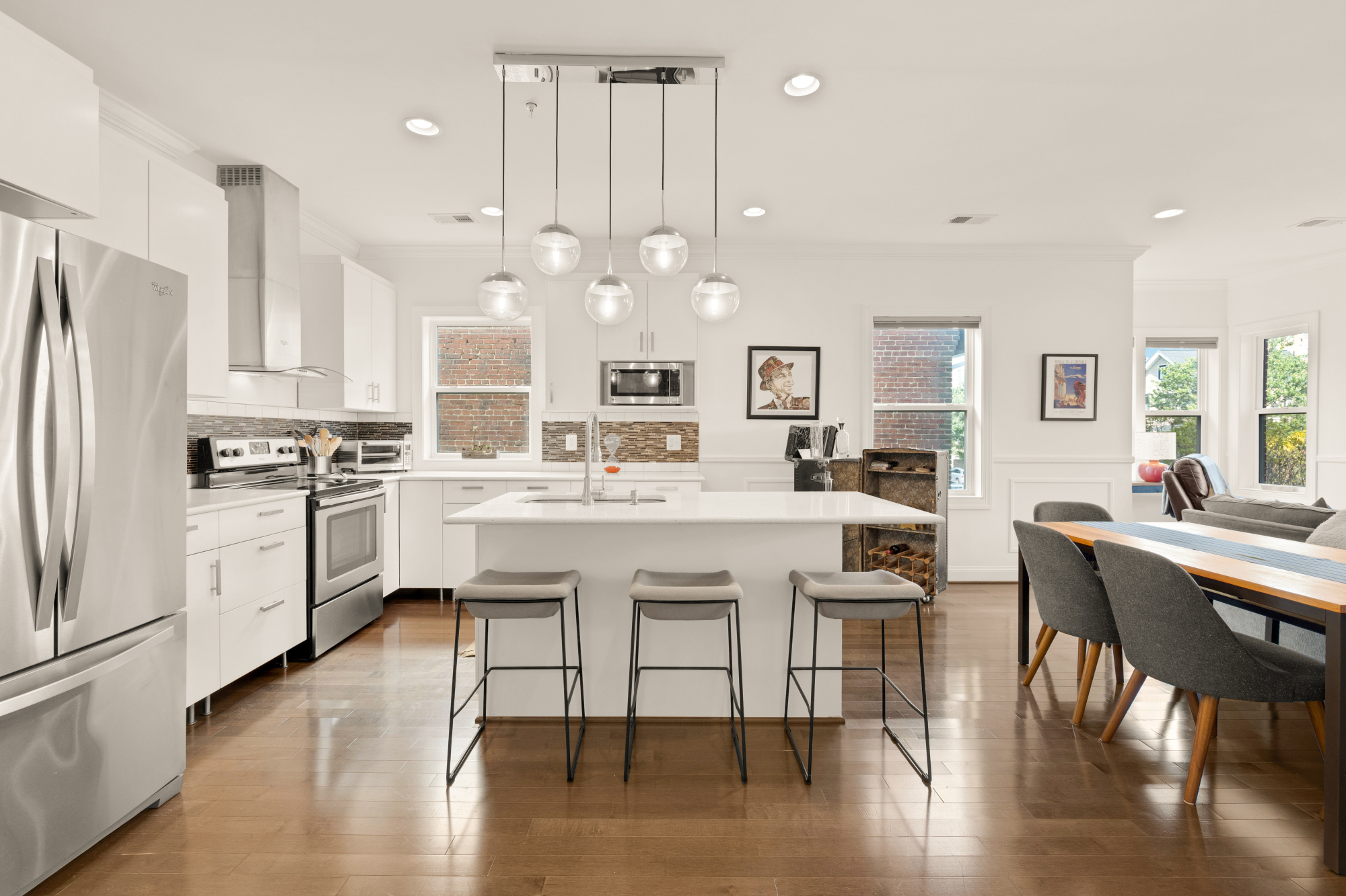 233 S Street Northeast, Unit 4 Washington, DC 20002 - Photo 12 of 37 a kitchen with a table chairs wooden floor and stainless steel appliances