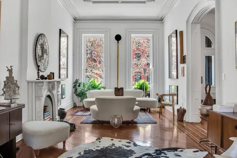 a living room with fireplace furniture and a large window
