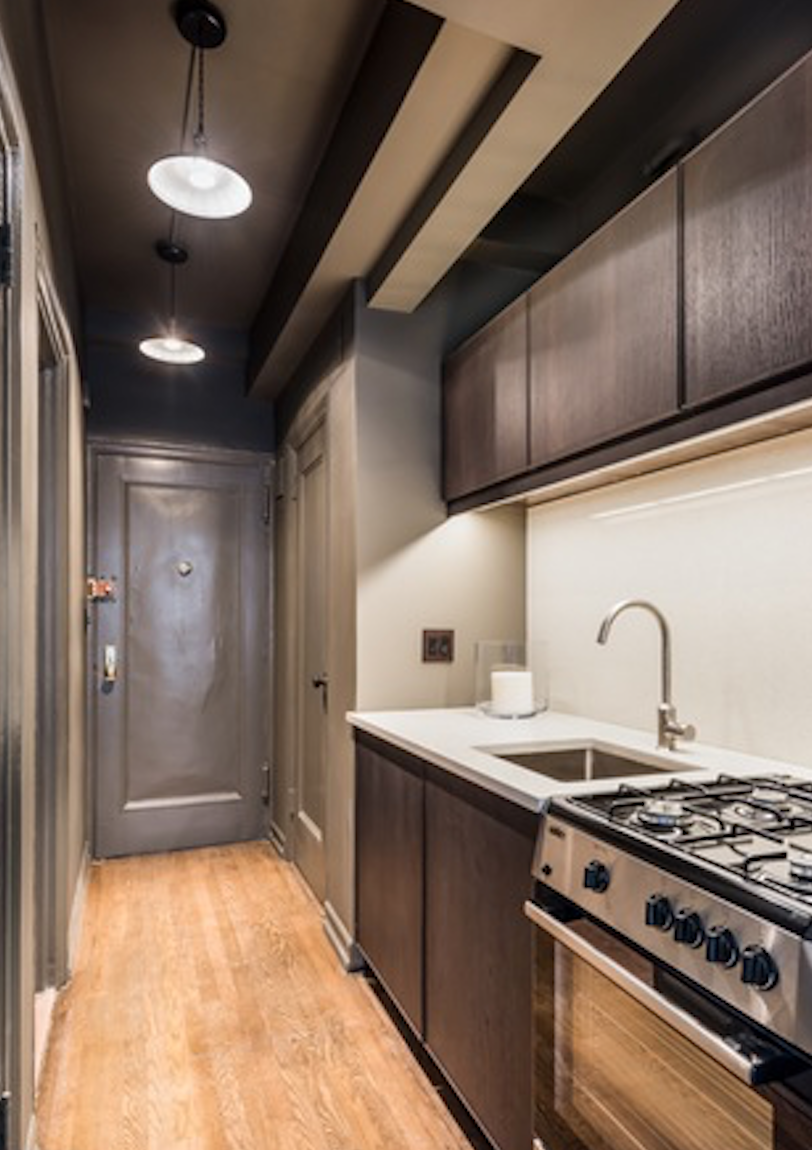 433 West 34th Street, Unit 9E Manhattan, NY 10001 - Photo 6 of 10 a kitchen with stainless steel appliances granite countertop a stove a refrigerator and a oven with wooden floor