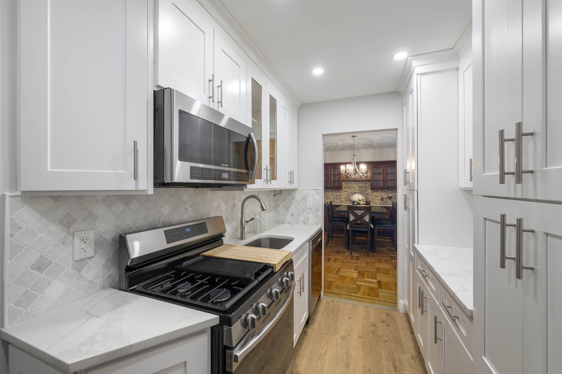 3215 Netherland Avenue, Unit 5C Bronx, NY 10463 - Photo 8 of 14 a kitchen with stainless steel appliances a stove a microwave and cabinets
