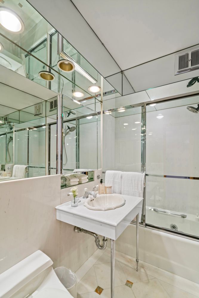 120 Central Park South, Unit 6ABC Manhattan, NY 10019 - Photo 16 of 17 a view of a bathroom with a sink mirror and a shower