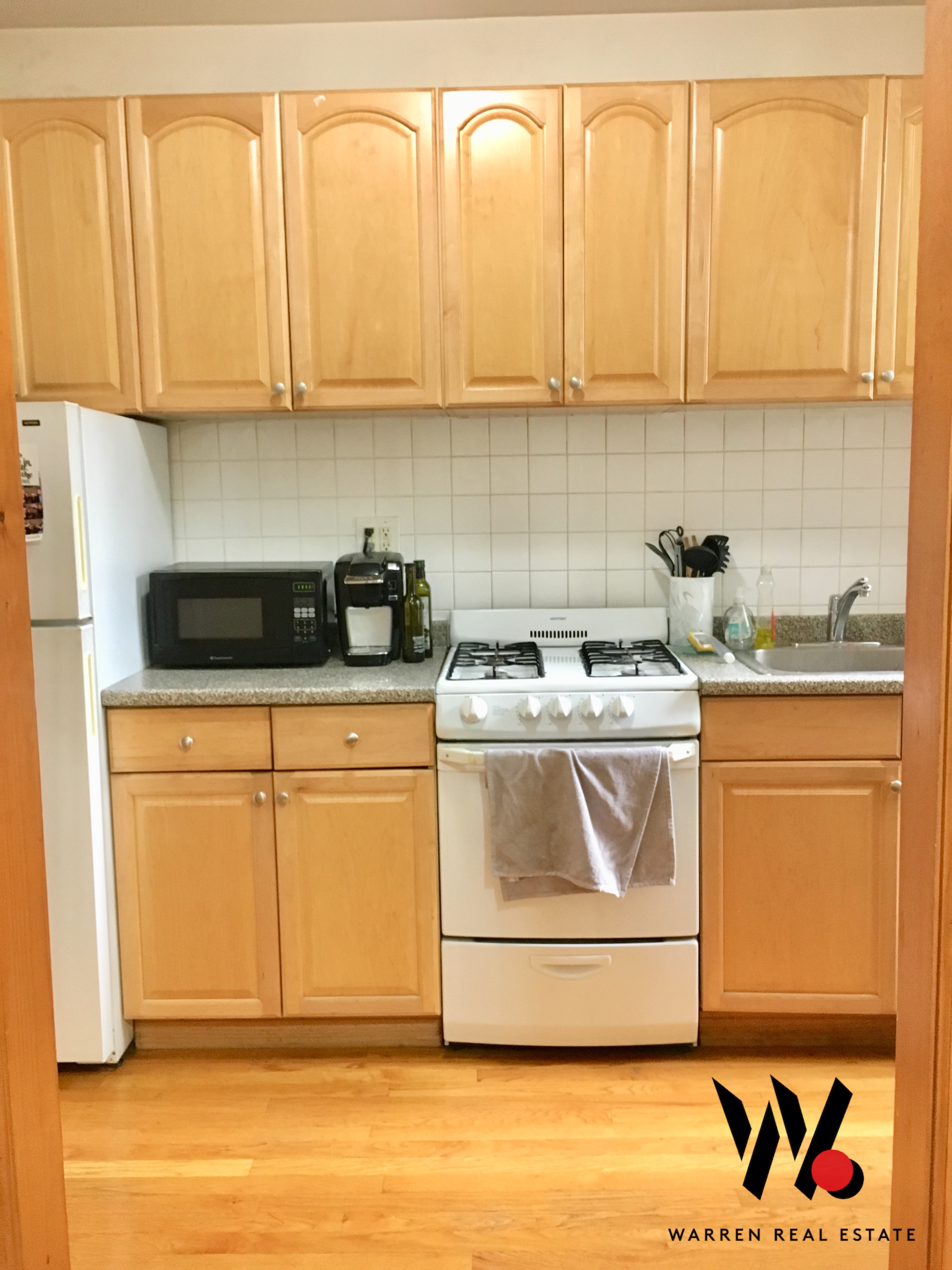 80 East 7th Street, Unit 4D Manhattan, NY 10003 - Photo 6 of 8 a kitchen with stainless steel appliances granite countertop a stove a sink and white cabinets