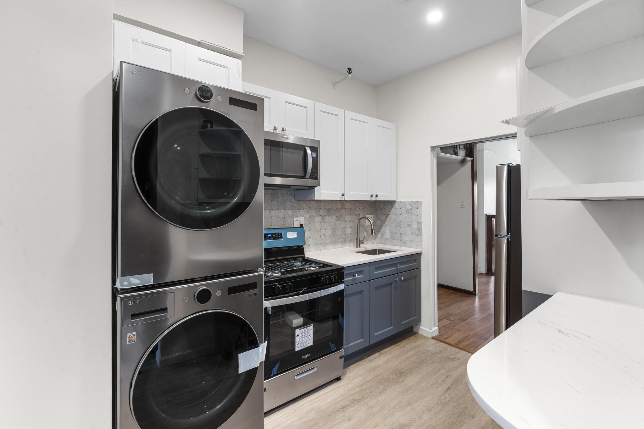 880 Park Place, Unit 2 Brooklyn, NY 11216 - Photo 10 of 12 a kitchen with stainless steel appliances granite countertop a sink a stove a refrigerator and a microwave