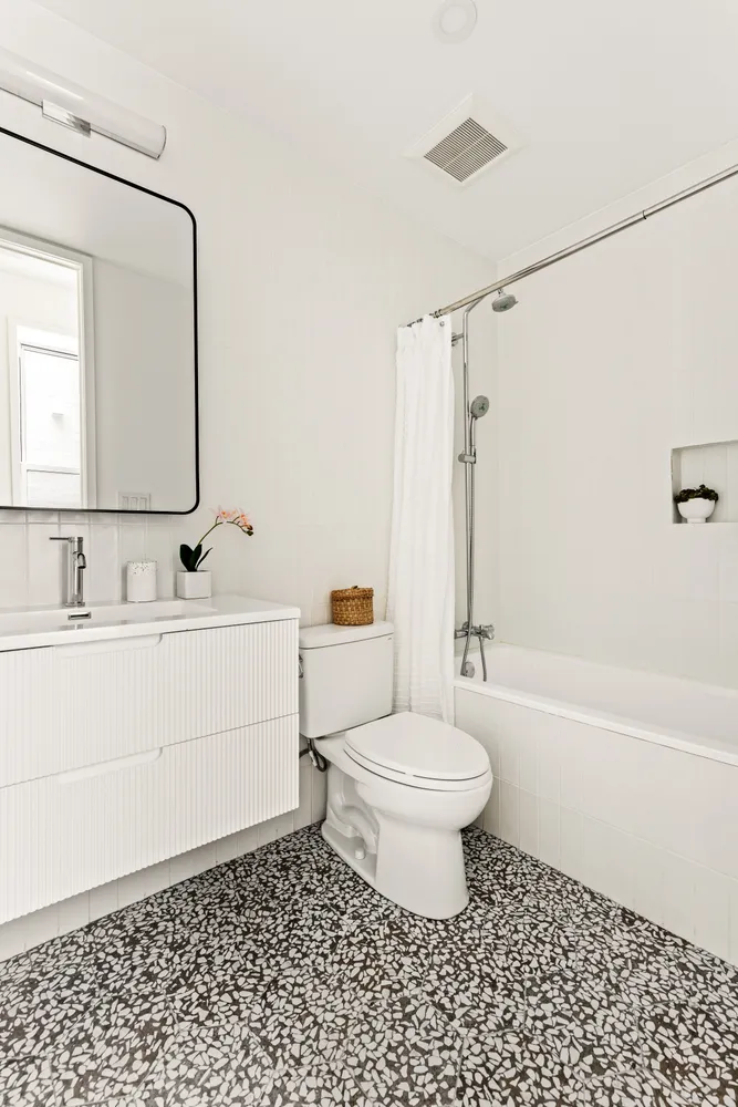 a bathroom with a sink a toilet and a mirror