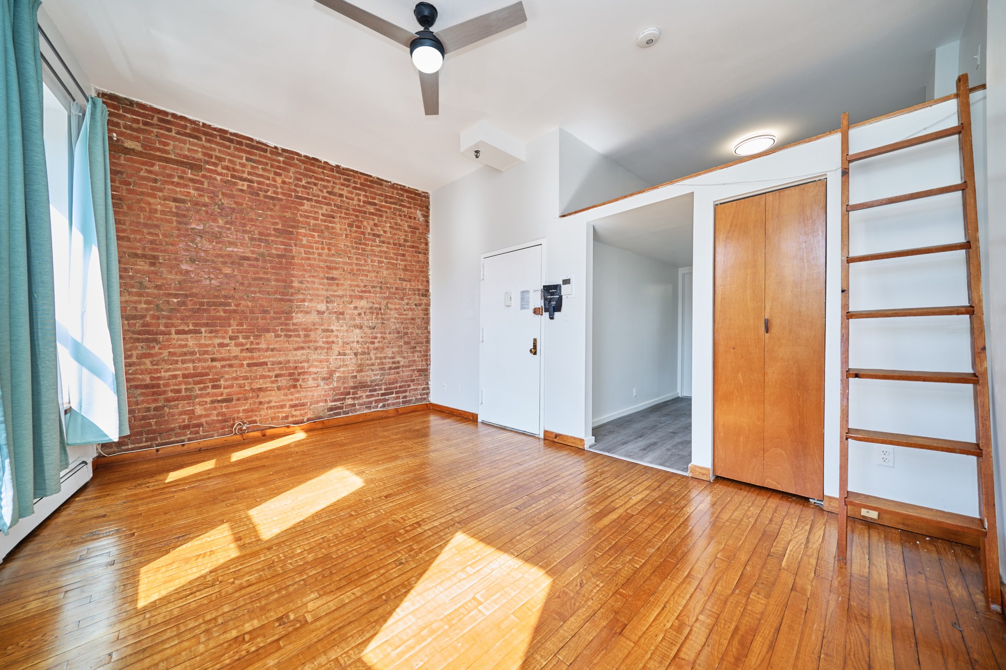 357 West 120th Street, Unit 2F Manhattan, NY 10027 - Photo 3 of 8 a view of an empty room with a window and wooden floor
