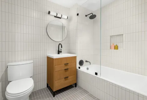 a bathroom with a sink a toilet and shower
