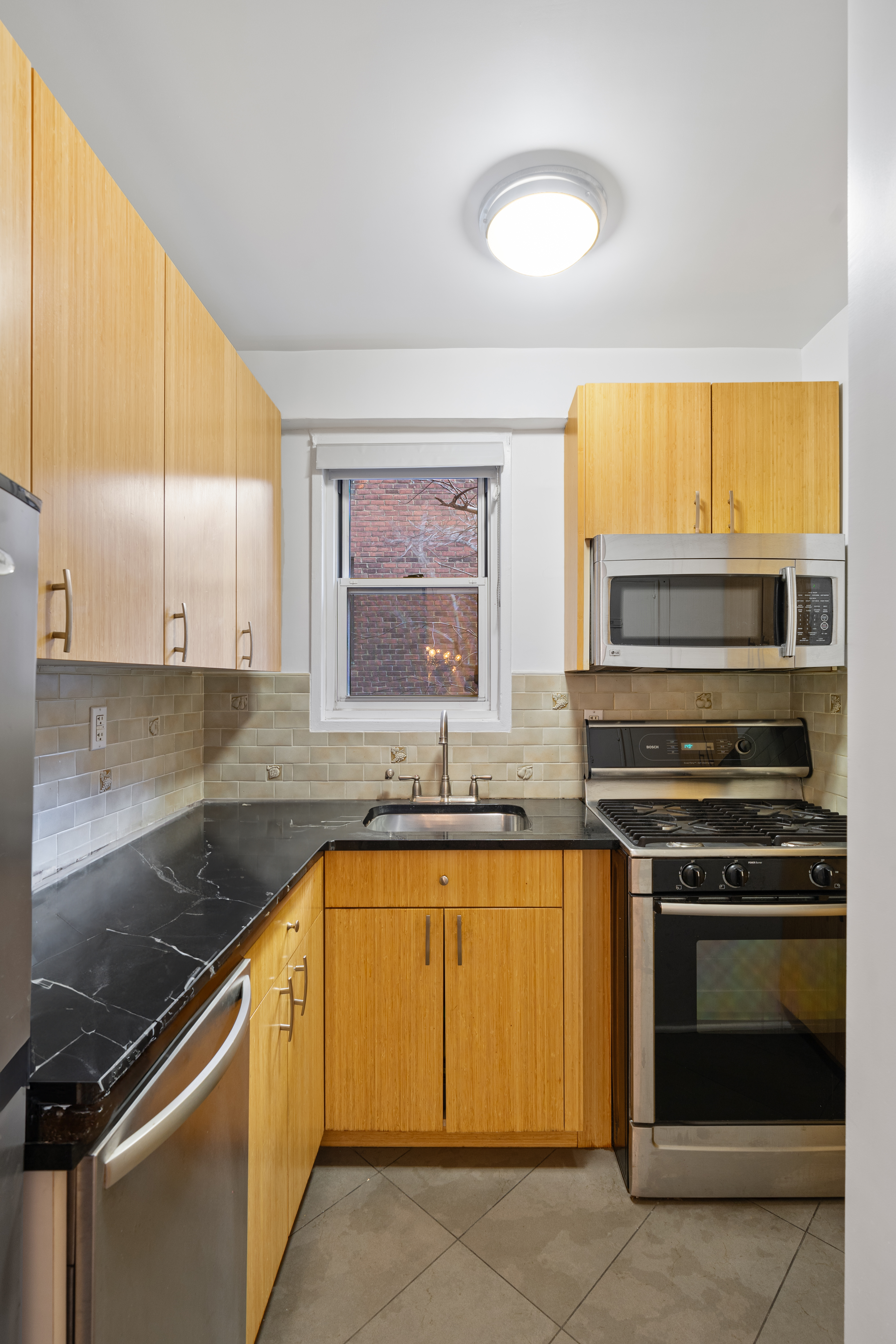 14 Horatio Street, Unit 2J Manhattan, NY 10014 - Photo 5 of 9 a kitchen with granite countertop a stove sink and cabinets