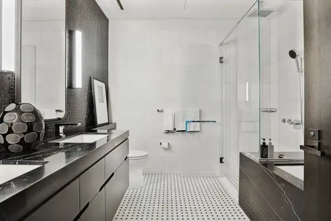 a bathroom with a double vanity sink a mirror and a shower