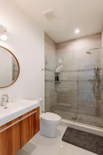 a bathroom with a sink a toilet and shower