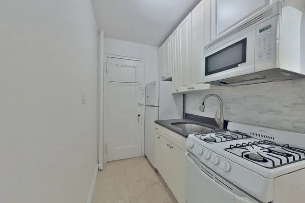a stove top oven sitting inside of a kitchen