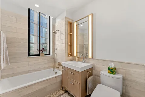a bathroom with a granite countertop toilet a sink and a bathtub