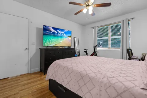 a bedroom with a bed and a flat tv screen on dresser