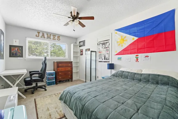 a bedroom with a bed wooden floor and chair