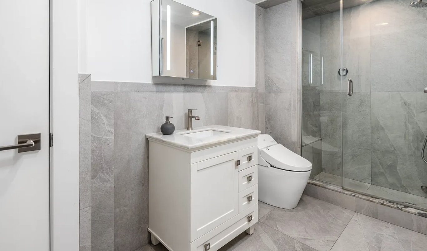 179 East 79th Street, Unit 1B Manhattan, NY 10075 - Photo 7 of 8 a utility room with a sink a toilet and shower