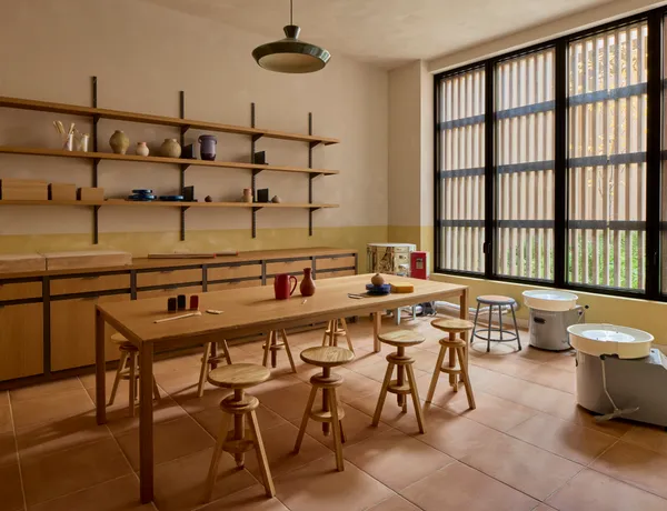 a dining hall with stainless steel appliances kitchen island a table and chairs