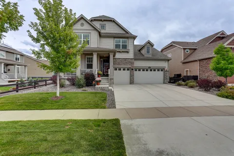 a front view of a house with a yard and trees