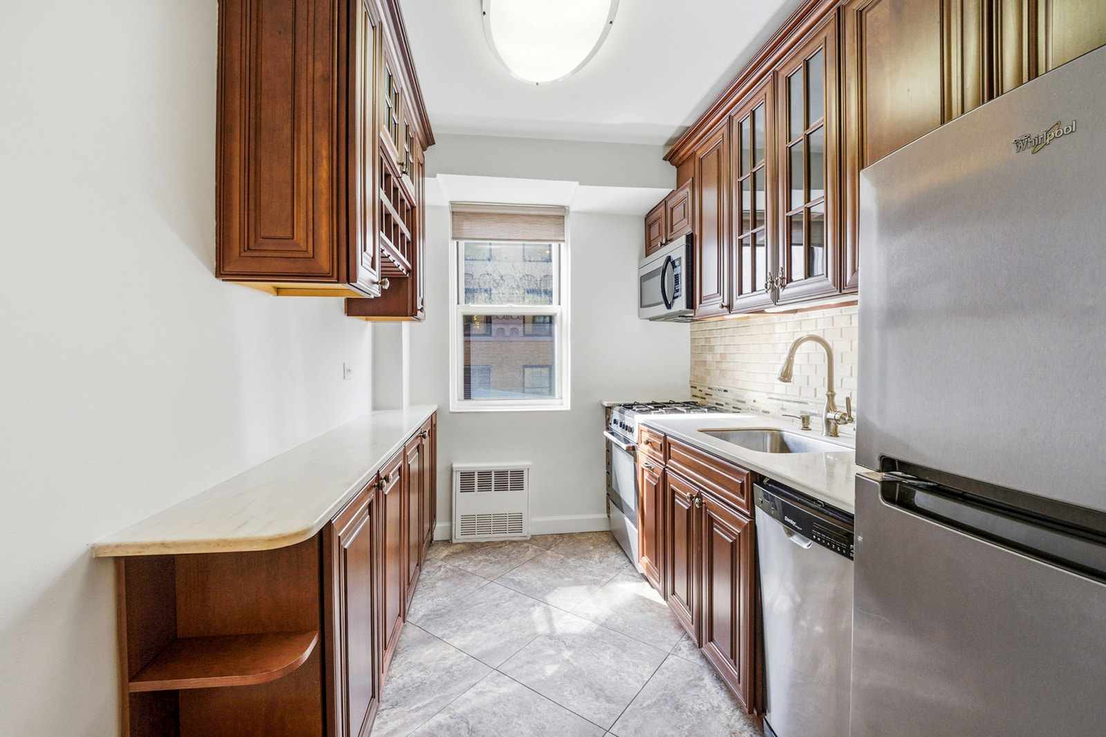 139 East 33rd Street, Unit 12DE Manhattan, NY 10016 - Photo 20 of 27 a kitchen with stainless steel appliances granite countertop a sink and cabinets
