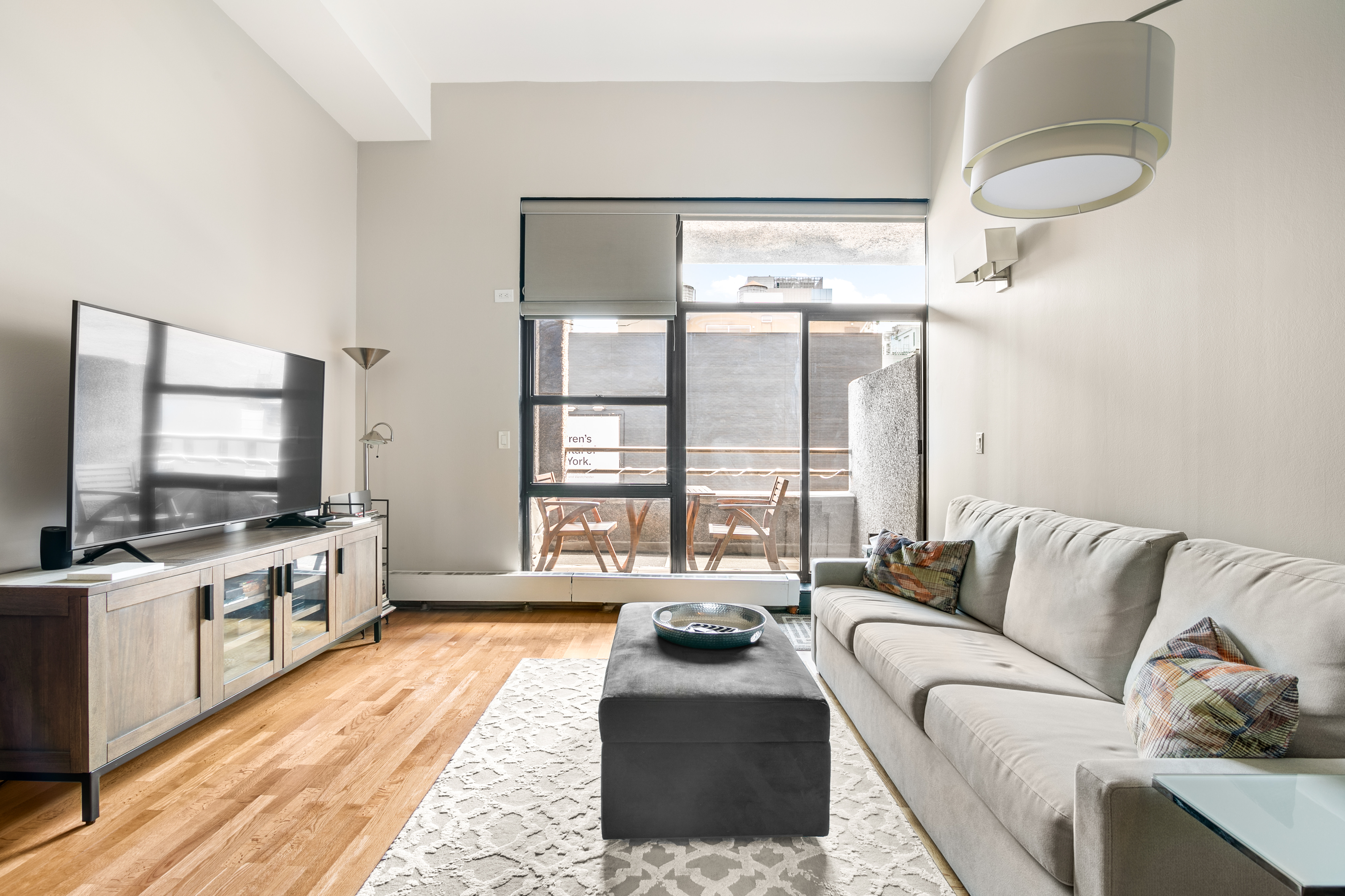 350 East 62nd Street, Unit 4B Manhattan, NY 10065 - Photo 2 of 9 a living room with furniture and a flat screen tv