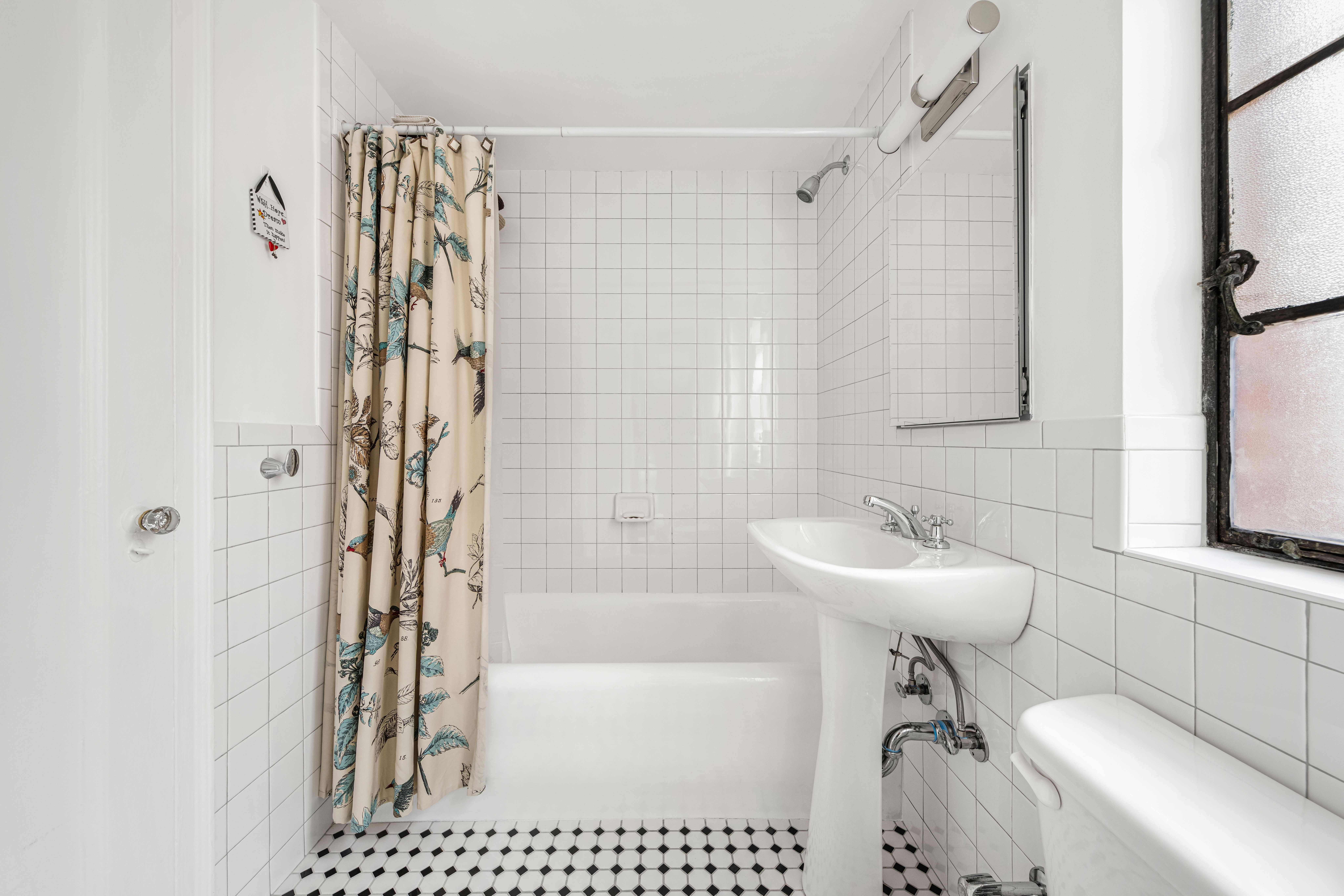 333 East 43rd Street, Unit 906 Manhattan, NY 10017 - Photo 6 of 17 a bathroom with a sink a toilet a mirror and shower