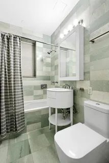 a bathroom with a sink a toilet a mirror and bathtub