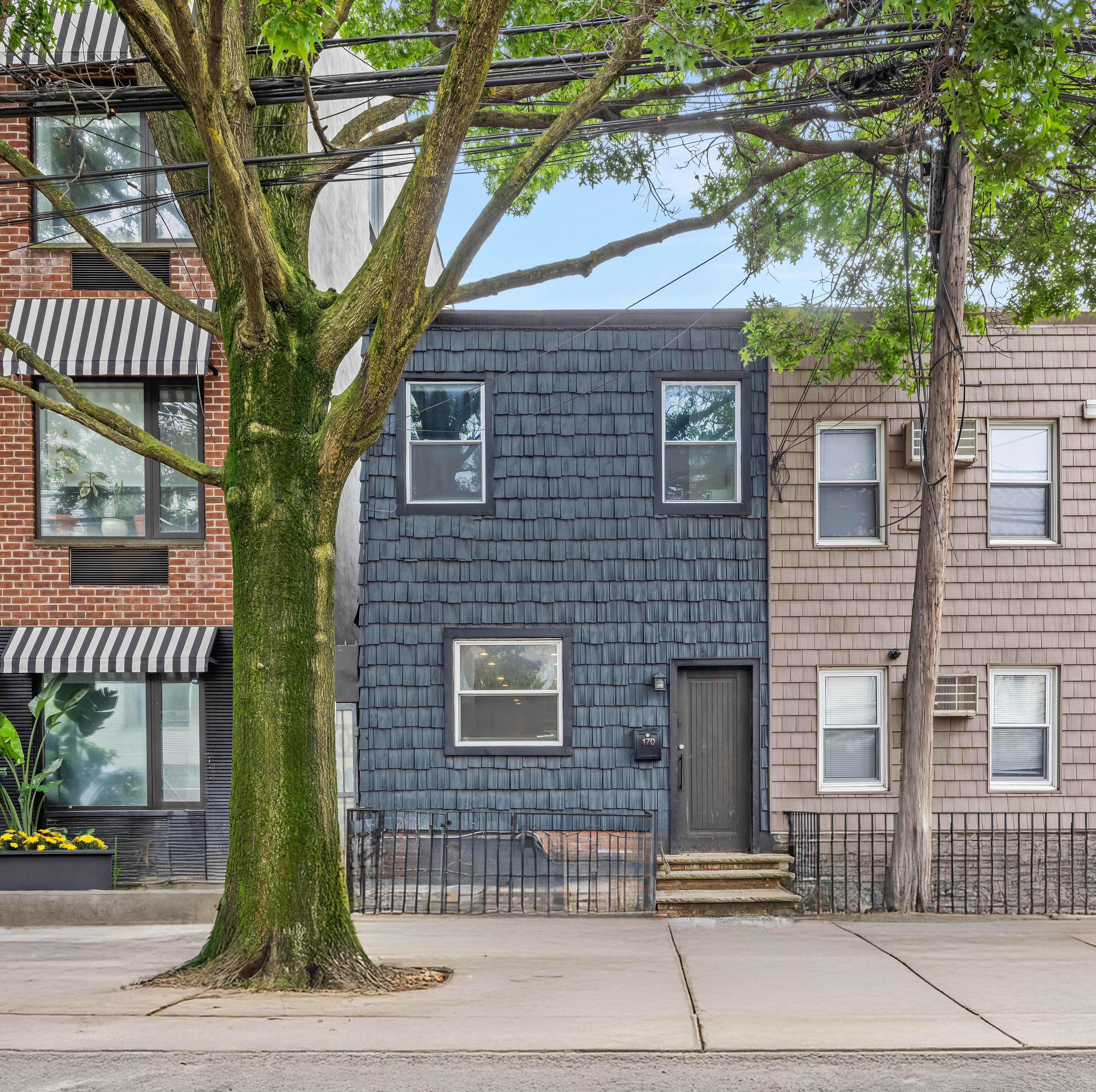 a view of a brick house with a tree front of it