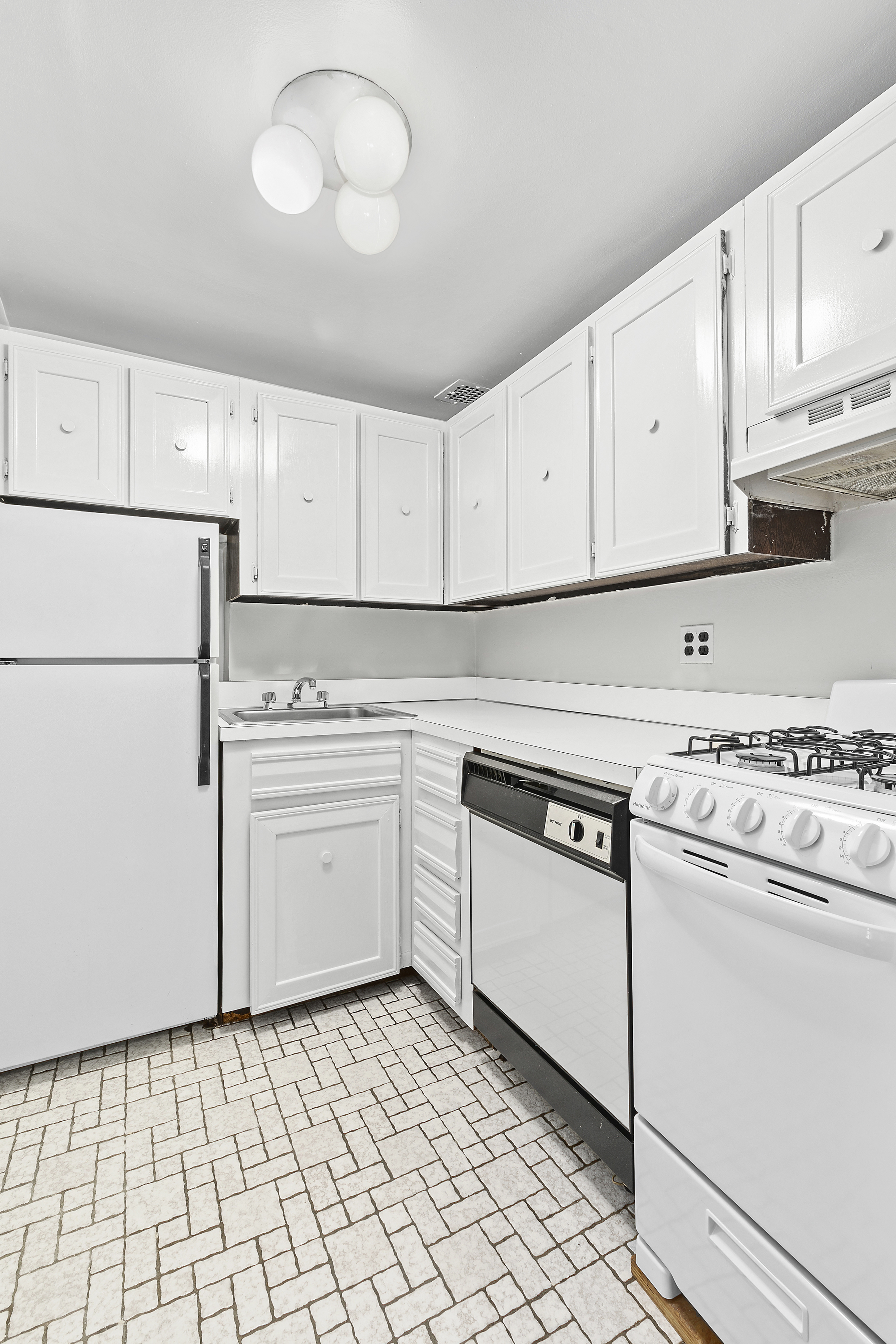 59 East 74th Street, Unit 7 Manhattan, NY 10021 - Photo 3 of 5 a kitchen with white cabinets and white appliances