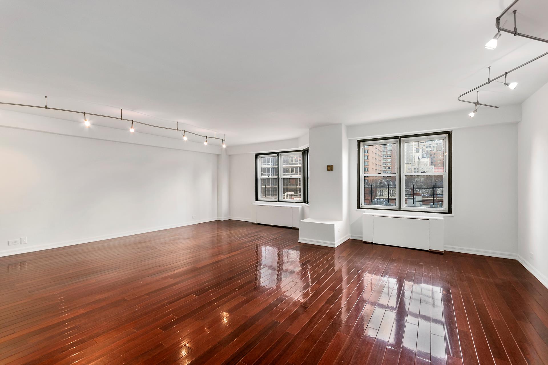 220 East 60th Street, Unit 7CD Manhattan, NY 10022 - Photo 7 of 11 a view of an empty room with wooden floor and a window