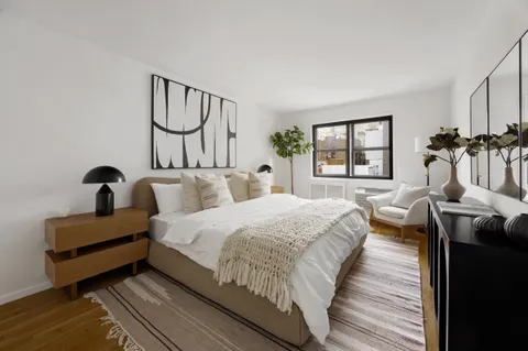 a spacious bedroom with bed and a window