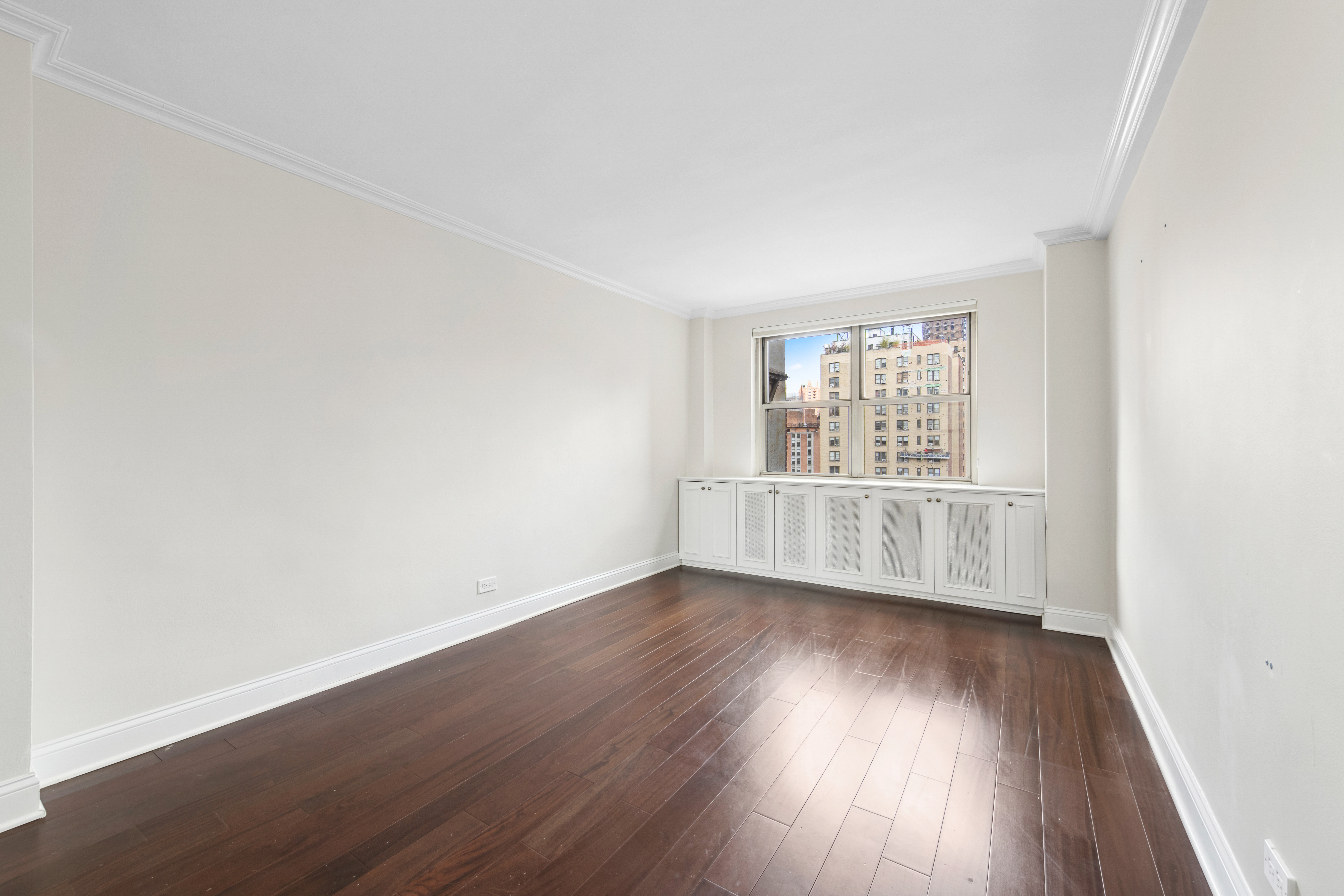 233 East 70th Street, Unit 11P Manhattan, NY 10021 - Photo 7 of 15 an empty room with wooden floor and windows