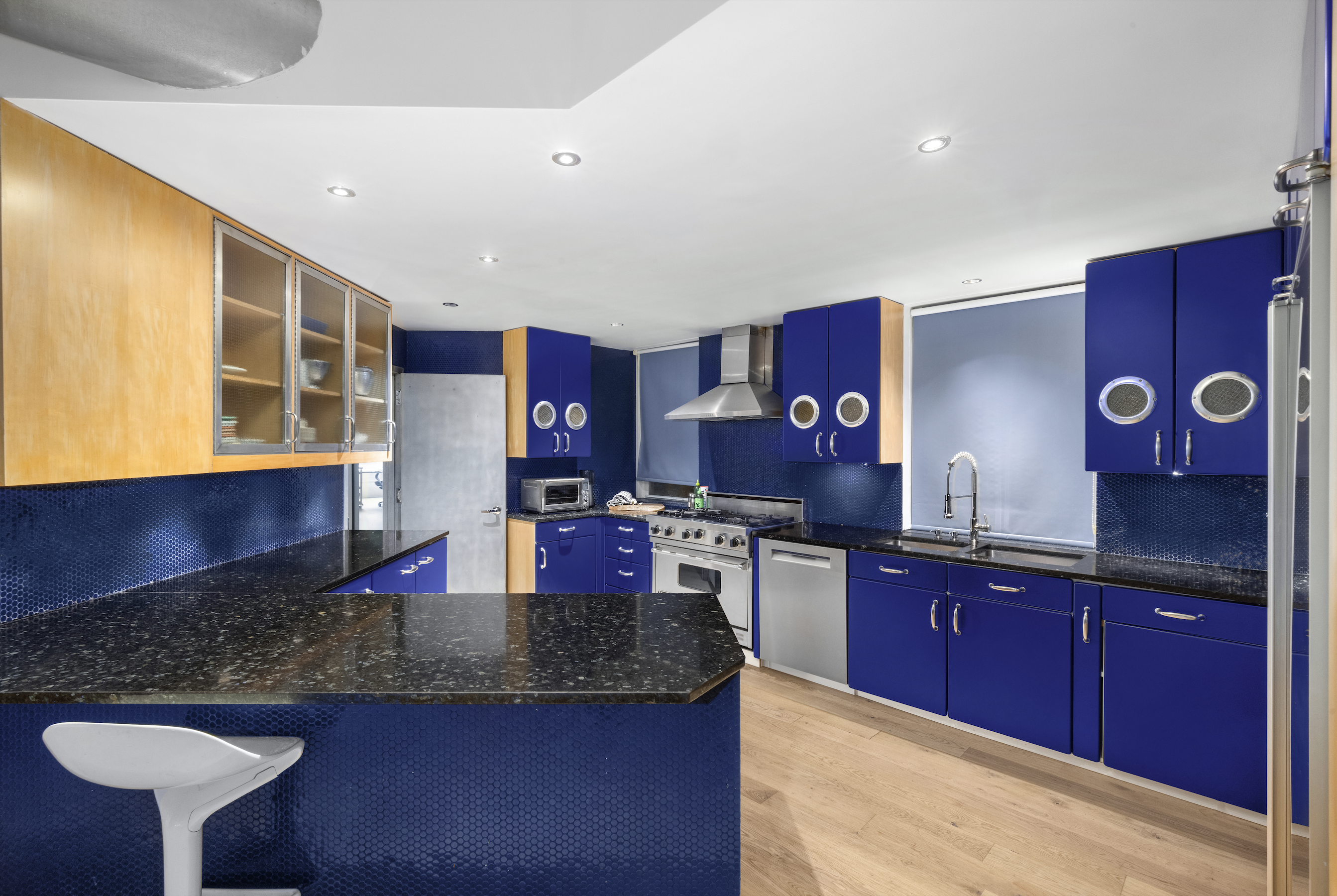 253 West 28th Street, Unit 5 Manhattan, NY 10001 - Photo 17 of 19 a kitchen with stainless steel appliances granite countertop a sink wooden cabinets and a granite counter top