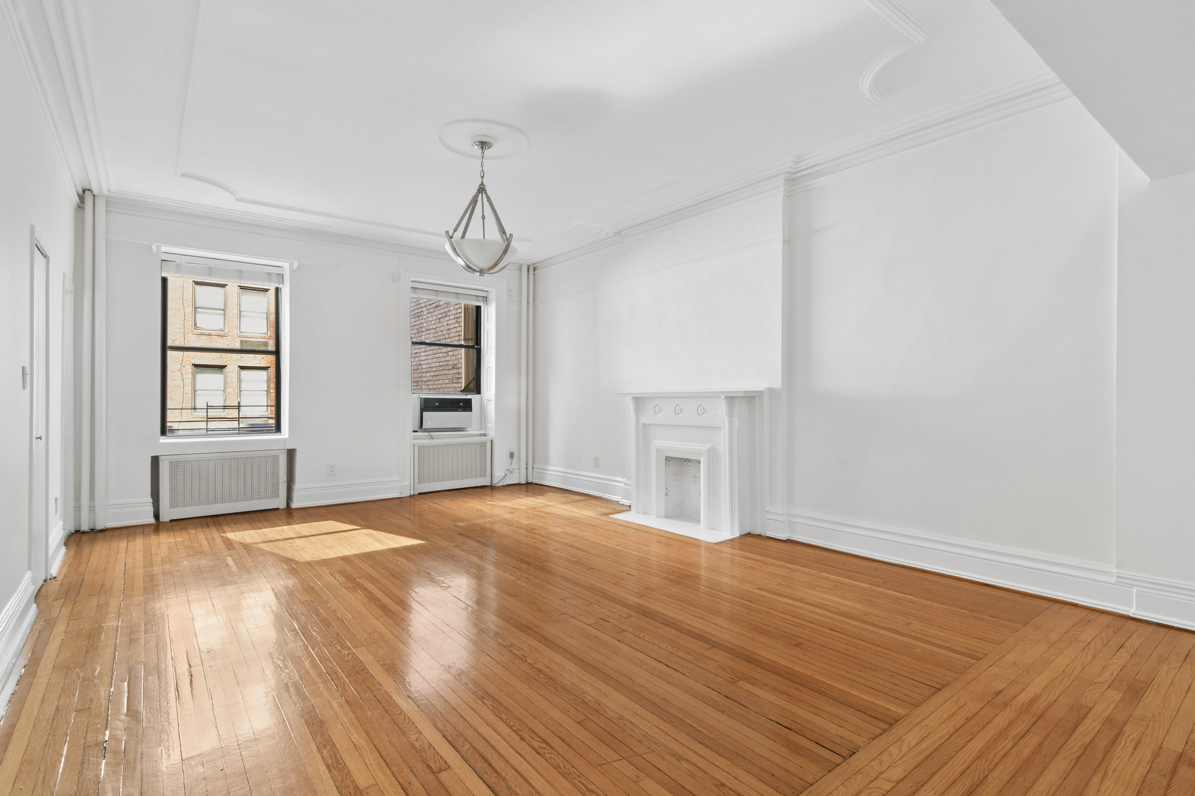 109 East 38th Street, Unit 3A Manhattan, NY 10016 - Photo 8 of 13 a view of empty room with wooden floor and windows