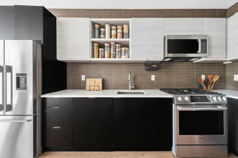 a kitchen with stainless steel appliances a stove a sink and a microwave