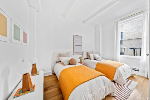 a bedroom with two beds and a large window