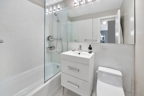 77 7th Avenue, Unit 9E Manhattan, NY 10011 - Photo 5 of 9 a bathroom with a sink a toilet and shower