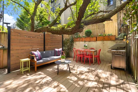a view of a patio with a table chairs and a fire pit