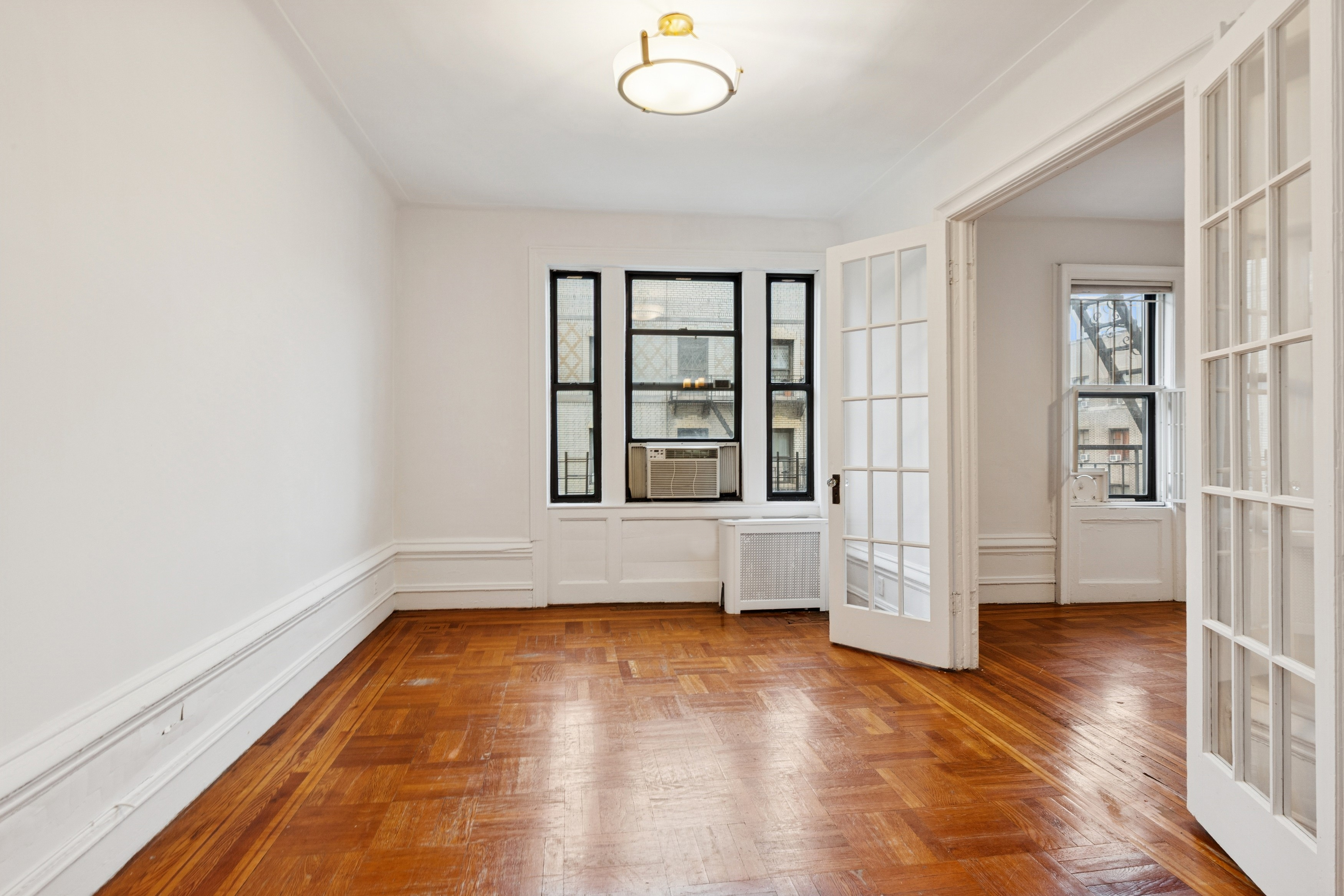 804 West 180th Street, Unit 41 Manhattan, NY 10033 - Photo 2 of 23 wooden floor in an empty room with a window