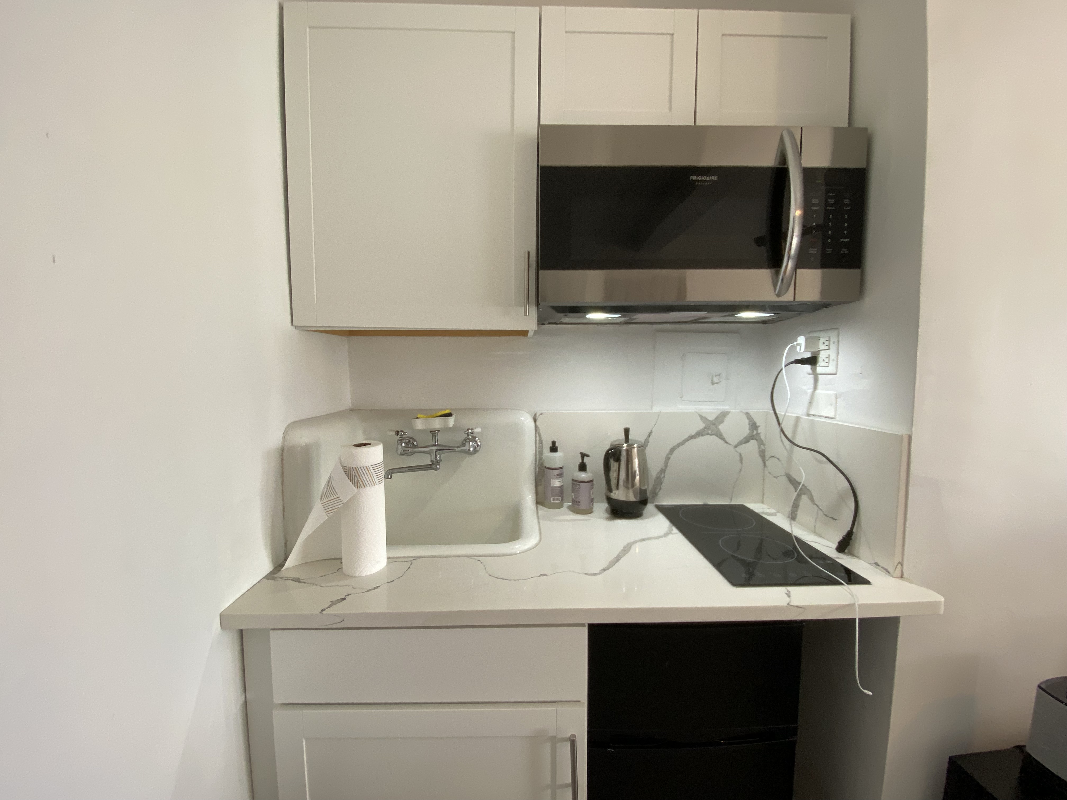 5 Tudor City Place, Unit 1226 Manhattan, NY 10017 - Photo 4 of 10 a kitchen with a sink and a microwave