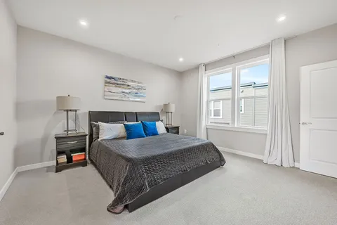 a living room with a bed furniture and next to a window