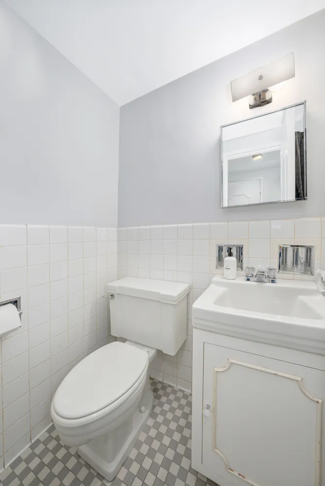 a bathroom with a sink toilet vanity and mirror