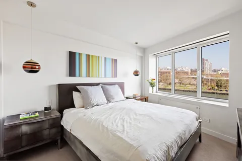 a bedroom with a bed and a large window