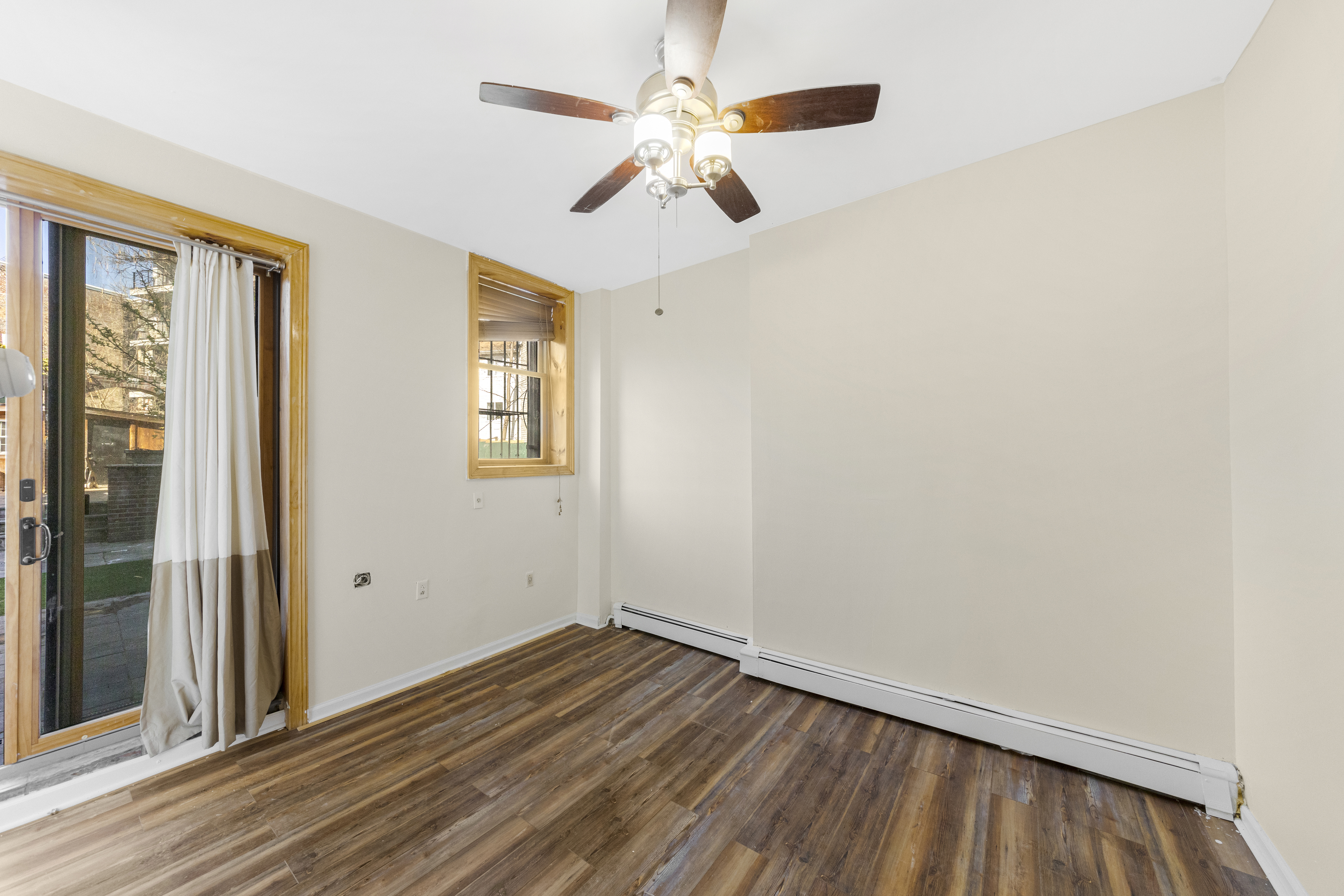 1061 Fulton Street, Unit 1 Brooklyn, NY 11238 - Photo 6 of 13 a view of empty room with wooden floor and fan