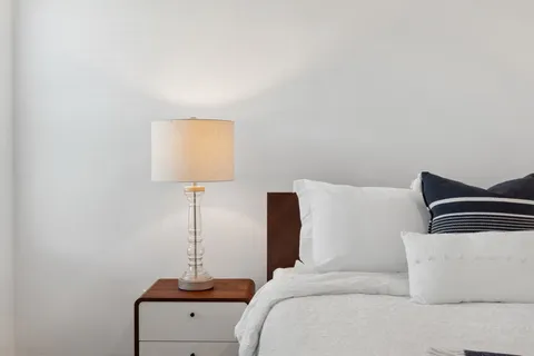 a bedroom with a lamp beds and lamp