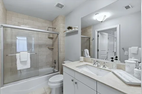 a bathroom with a granite countertop sink a toilet and shower