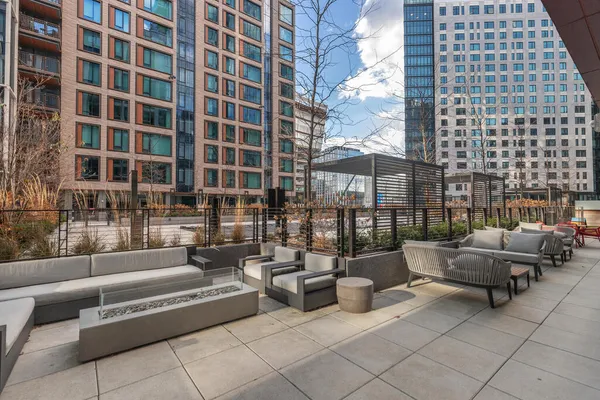 a roof deck with couches and a potted plant