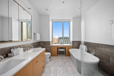 a bathroom with a granite countertop toilet sink and mirror