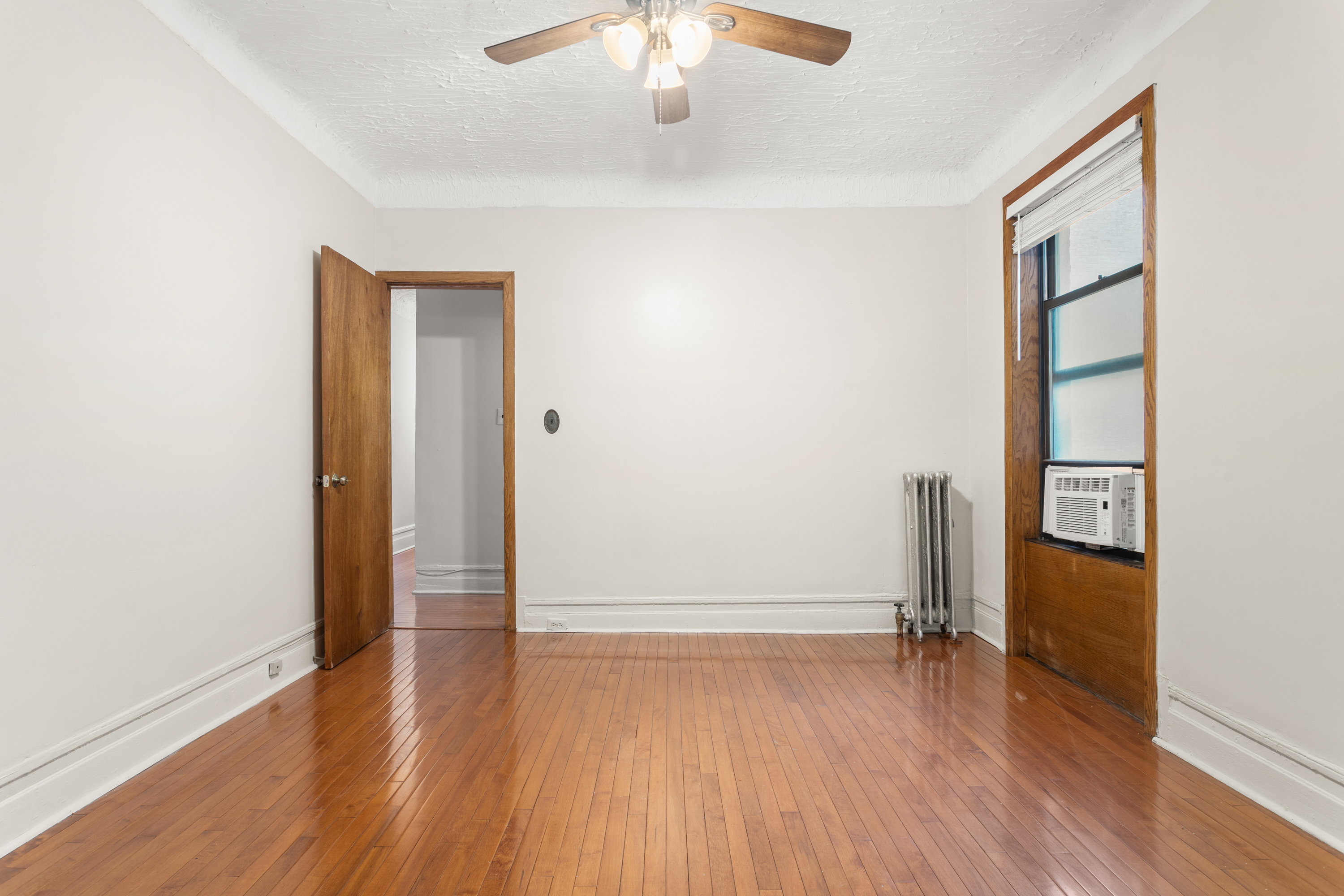 527 West 143rd Street, Unit 31 Manhattan, NY 10031 - Photo 16 of 29 an empty room with wooden floor and windows