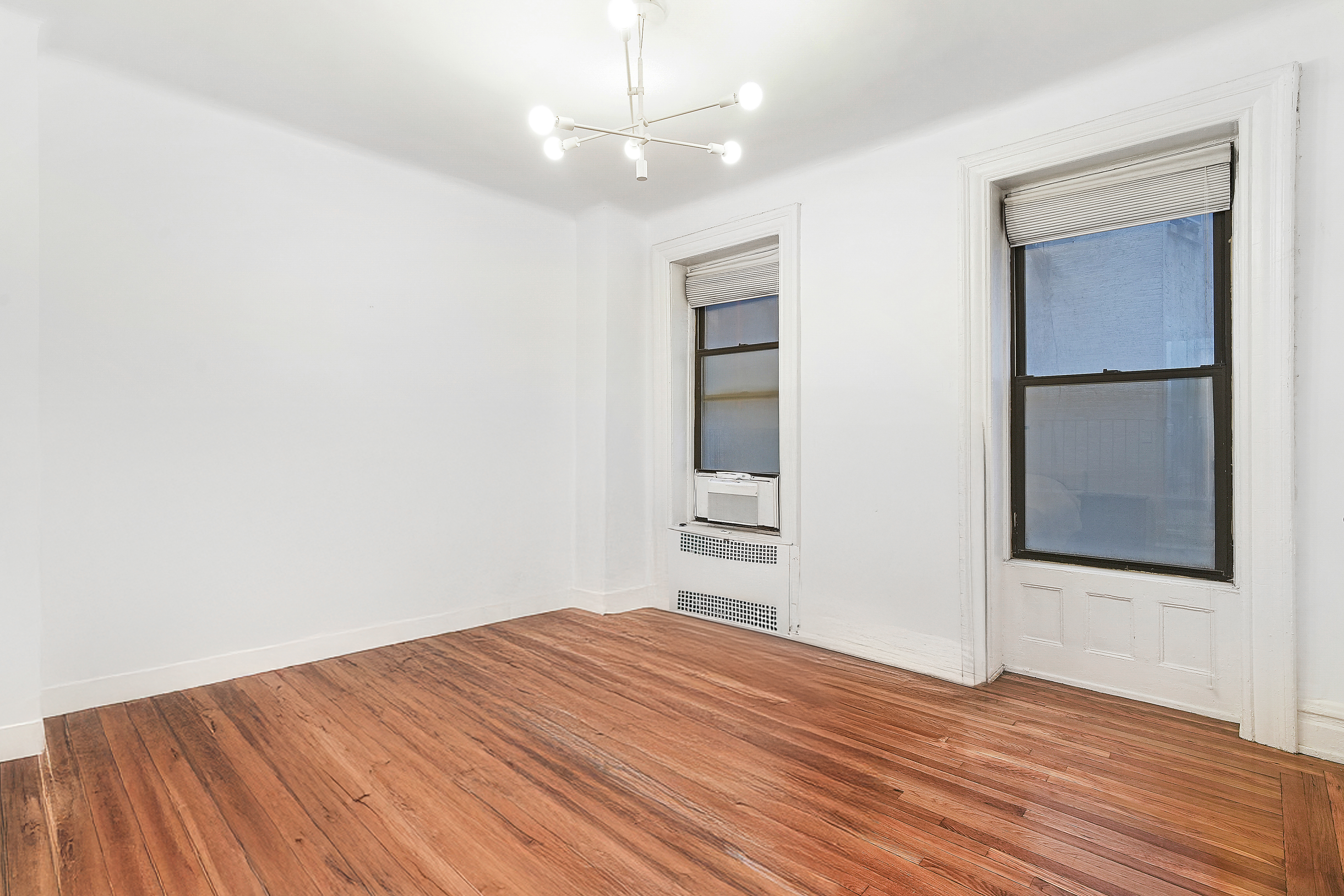 205 West 54th Street, Unit 3A Manhattan, NY 10019 - Photo 6 of 14 wooden floor in an empty room with a window