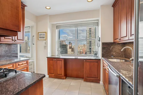 a kitchen with stainless steel appliances granite countertop a sink and a stove